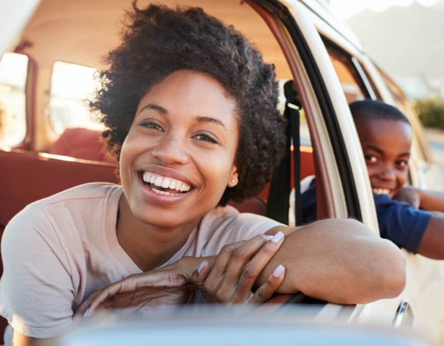 Smiling woman and sun in car