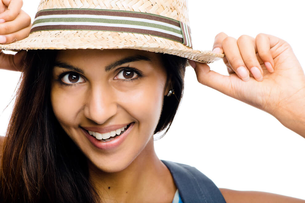 Women in hat smiling. She may represent an ICL eye surgery patient